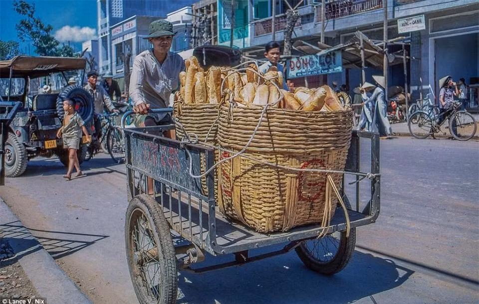 Một người đàn ông đang chở bánh mỳ đi bán.