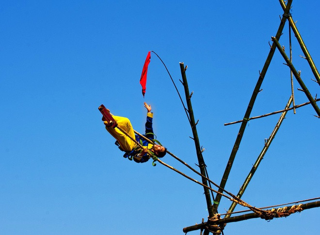 br/> Hàng năm cứ vào ngày mùng 2 Tết, người dân xã Điền Hòa, huyện Phong Điền (Thừa Thiên Huế) lại nô nức tổ chức lễ hội đu tiên. Cây đu tiên chuẩn bị từ nhiều ngày trước được buộc chắc chắn và đặt giữa khoảng đất rộng. Nam thanh nữ tú mặc những bộ quần áo sặc sỡ và được trang bị thiết bị bảo hộ sẽ bước lên chiếc đu, cố gắng đu thật cao và lâu. Ảnh: Lê Huy Hoàng Hải.