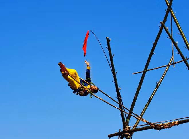 br/> Hàng năm cứ vào ngày mùng 2 Tết, người dân xã Điền Hòa, huyện Phong Điền (Thừa Thiên Huế) lại nô nức tổ chức lễ hội đu tiên. Cây đu tiên chuẩn bị từ nhiều ngày trước được buộc chắc chắn và đặt giữa khoảng đất rộng. Nam thanh nữ tú mặc những bộ quần áo sặc sỡ và được trang bị thiết bị bảo hộ sẽ bước lên chiếc đu, cố gắng đu thật cao và lâu. Ảnh: Lê Huy Hoàng Hải.