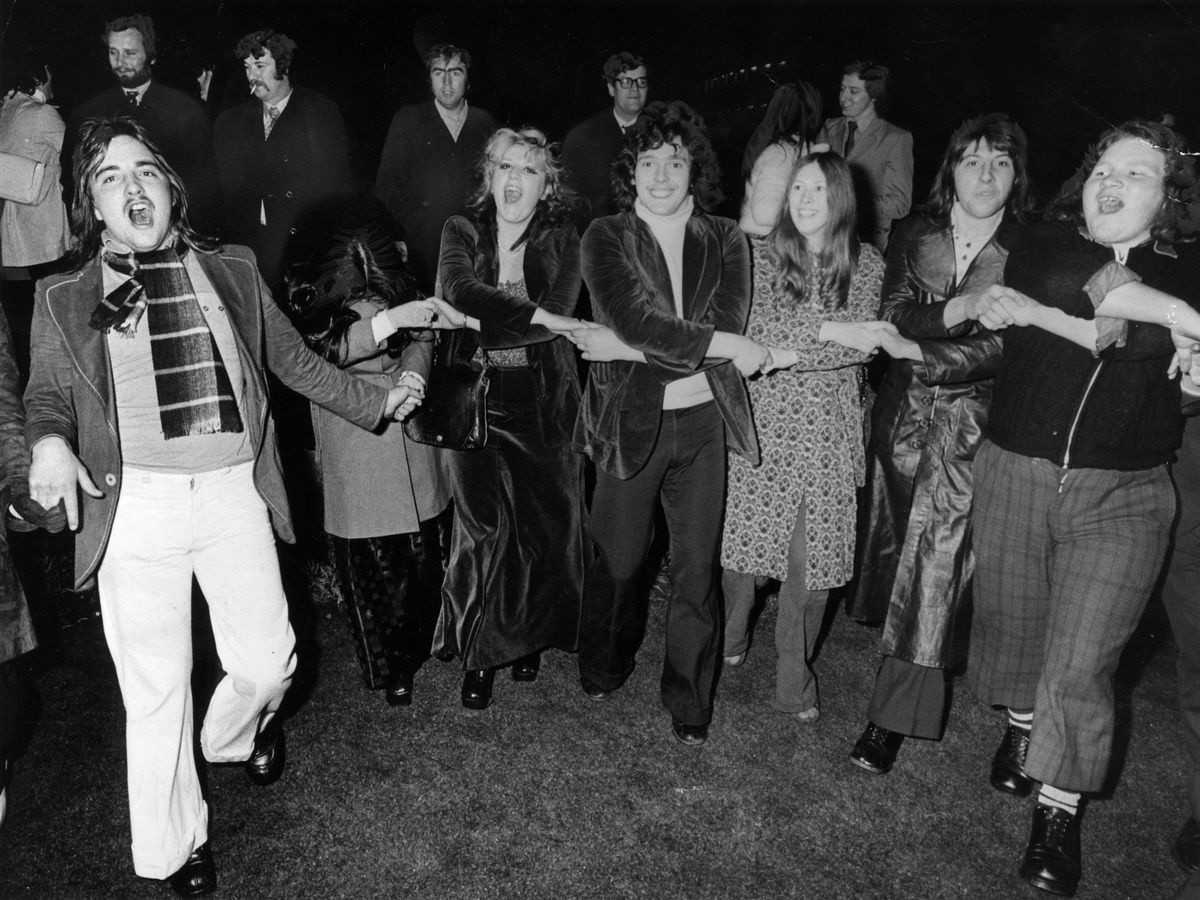 Auld Lang Syne là ca khúc năm mới của người dân Scotland. Theo The Week, ca khúc được nhà thơ Robert Burns sáng tác vào năm 1788. Bài hát nói về những người bạn, dù bước qua năm mới nhưng không quên những khoảng thời gian tốt đẹp ngày trước. Theo truyền thống, mọi người sẽ đứng thành vòng tròn, bắt chéo tay và cùng nhau hát Auld Lang Syne. Khi đến cuối bài hát, vòng tròn sẽ được thu nhỏ, tất cả kết thúc khoảnh khắc này bằng một cái ôm hoặc một nụ hôn. Ảnh: Bristol Live.