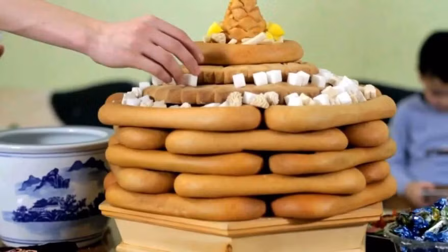 Bánh Ul boov với hình dạng như đế giày là loại đồ ăn không thể thiếu ở Mông Cổ trong dịp Tết. Món bánh ngọt này thường được ghép thành nhiều lớp và có đóng dấu bằng khối gỗ riêng của gia đình. Số lượng lớp trong bánh thể hiện địa vị của gia đình. Vào dịp Tết, người Mông Cổ xếp lớp bánh Ul boov theo số lẻ, tượng trưng cho hạnh phúc, ấm no. Ảnh: Random Times.