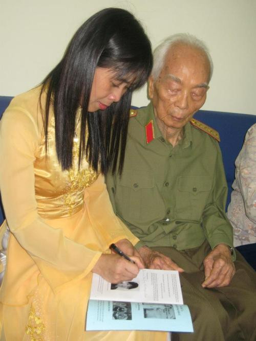 Chị Huỳnh Tiểu Hương ký tặng Đại tướng những hình ảnh hoạt động tại Trung tâm Nhân đạo Quê Hương