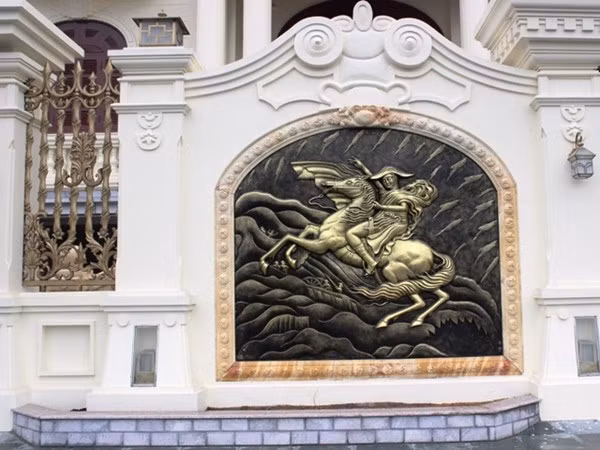 Gia chủ cũng tạo điểm nhấn cho bức tường bao căn biệt thự đôi bằng những bức tranh mạ đồng độc đáo.