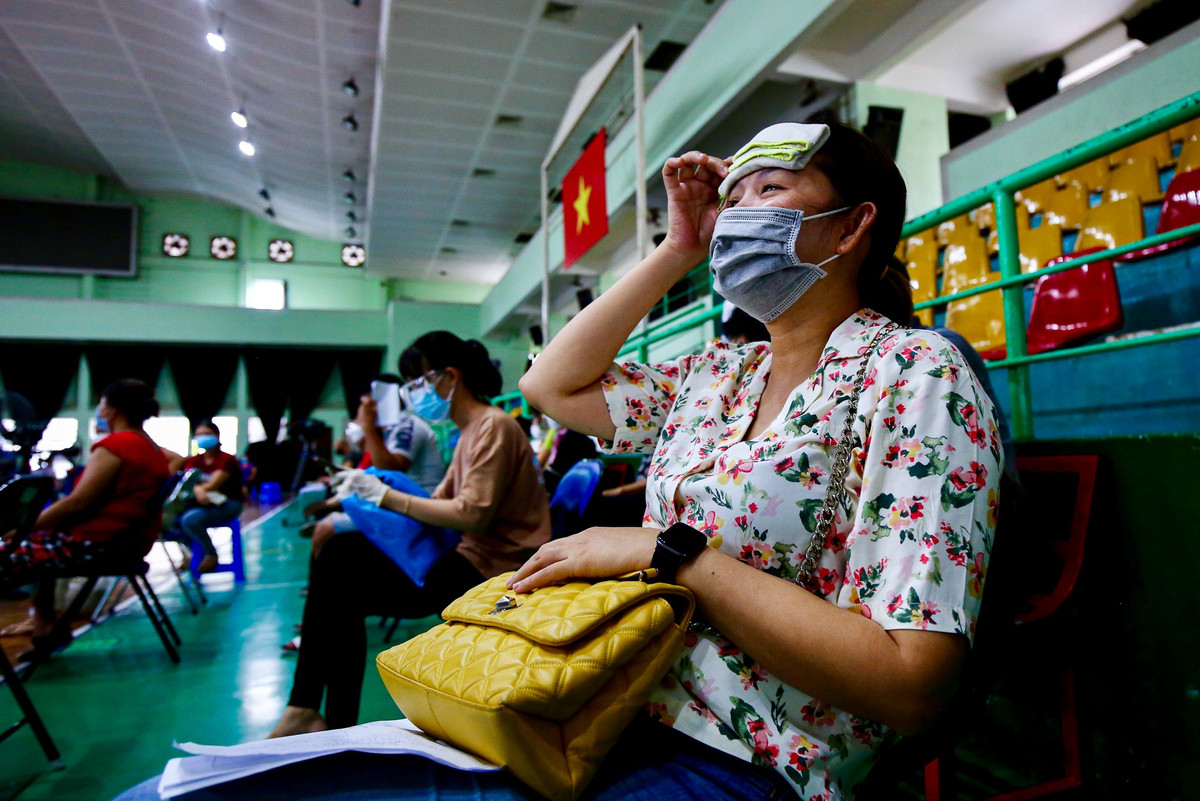“Sau khi khám sàng lọc, thân nhiệt của tôi hơi cao nên phải tranh thủ chườm khăn lạnh để nhiệt độ cơ thể ổn định mới vào tiêm được”, chị Như Quỳnh (36 tuổi) chia sẻ.