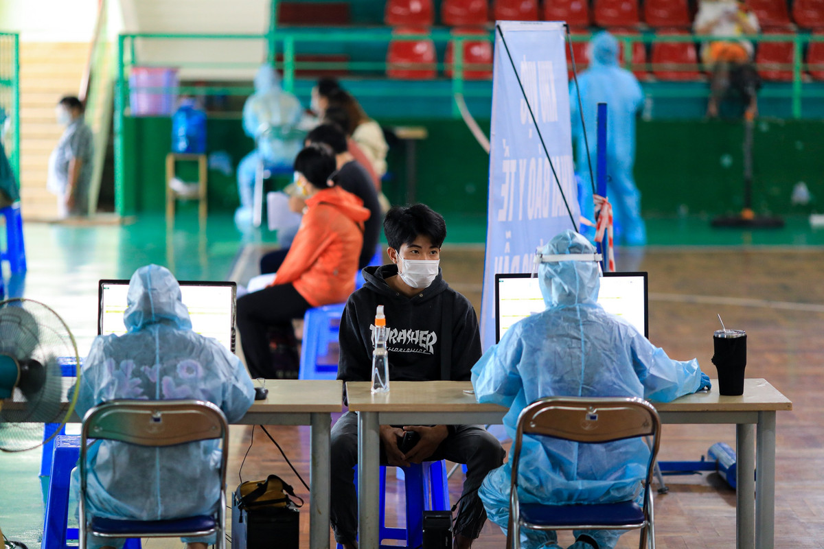 Tại bàn tiếp nhận đăng ký tiêm, nhân viên y tế kiểm tra, đối chiếu thông tin mà người dân đã khai báo. Đồng thời, các nhân viên y tế thông báo những người trên 65 tuổi, có bệnh nền, cần quay về chờ tiêm vaccine ở bệnh viện.