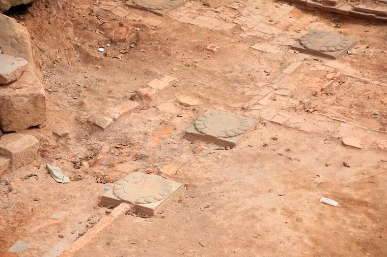 Hàng chục chân cột bằng đá kích thước khoảng 0,75 m x 0,75 m chạm cánh sen xuất hiện rải rác trên các cấp nền.