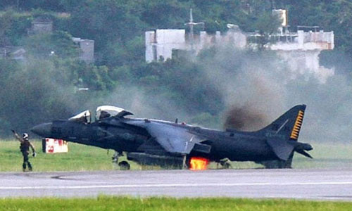 Máy bay cất hạ cánh thẳng đứng AV-8B bốc cháy ở phía sau.