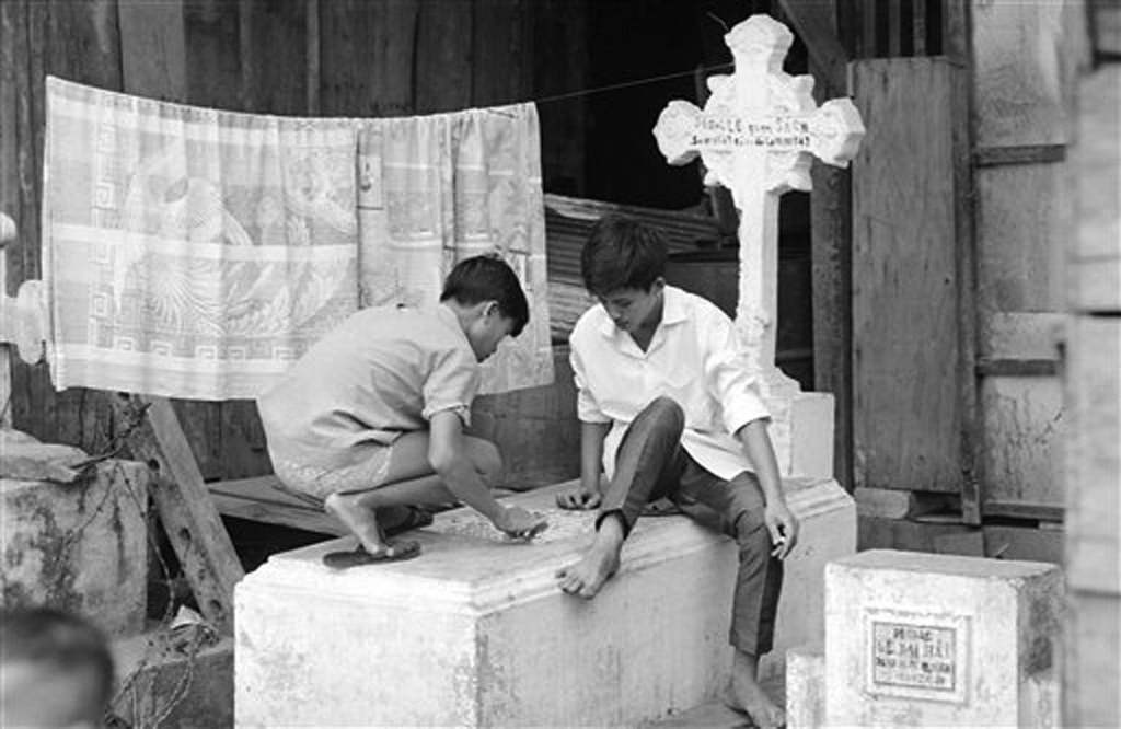 Hai thiếu niên dùng nấm mộ làm mặt bàn chơi cờ tướng. Năm 1979, mồ mả ở khu Mả Lạng được di dời. Khu vực này được kiến thiết lại, trở thành khu dân cư dành cho những người lang thang cơ nhỡ với các lô nhà đánh dấu từ A đến K...