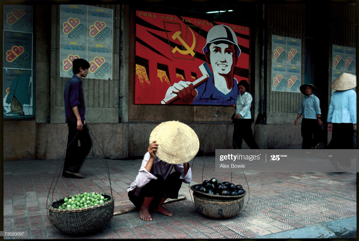 Người bán hàng rong trên vỉa hè Hà Nội lấy nón che mặt khi lọt vào ống kính máy ảnh, 23/5/1983.