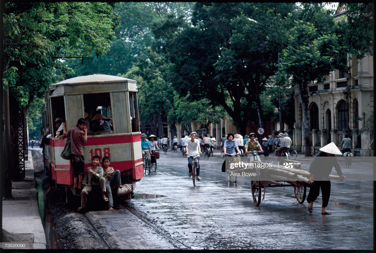 Những đứa trẻ đeo báo phía sau tại điện trên đường Đinh Tiên Hoàng, Hà Nội ngày 24/5/1983.