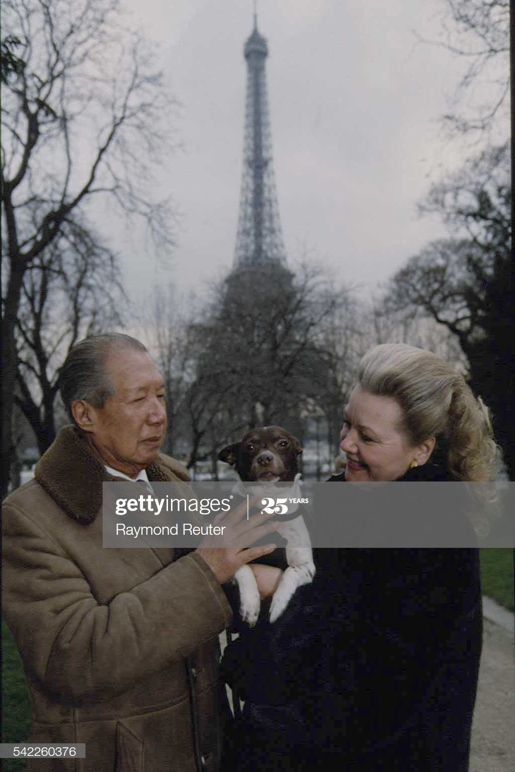 Bảo Đại và Monique Baudot đi dạo cùng chó cưng ở công viên gần tháp Eiffel, 1992. Monique Baudot đã tận tình giúp đỡ "ông vua lưu vong" và sống với ông từ năm 1971. Nhưng đến năm 1982 họ mới làm đám cưới.
