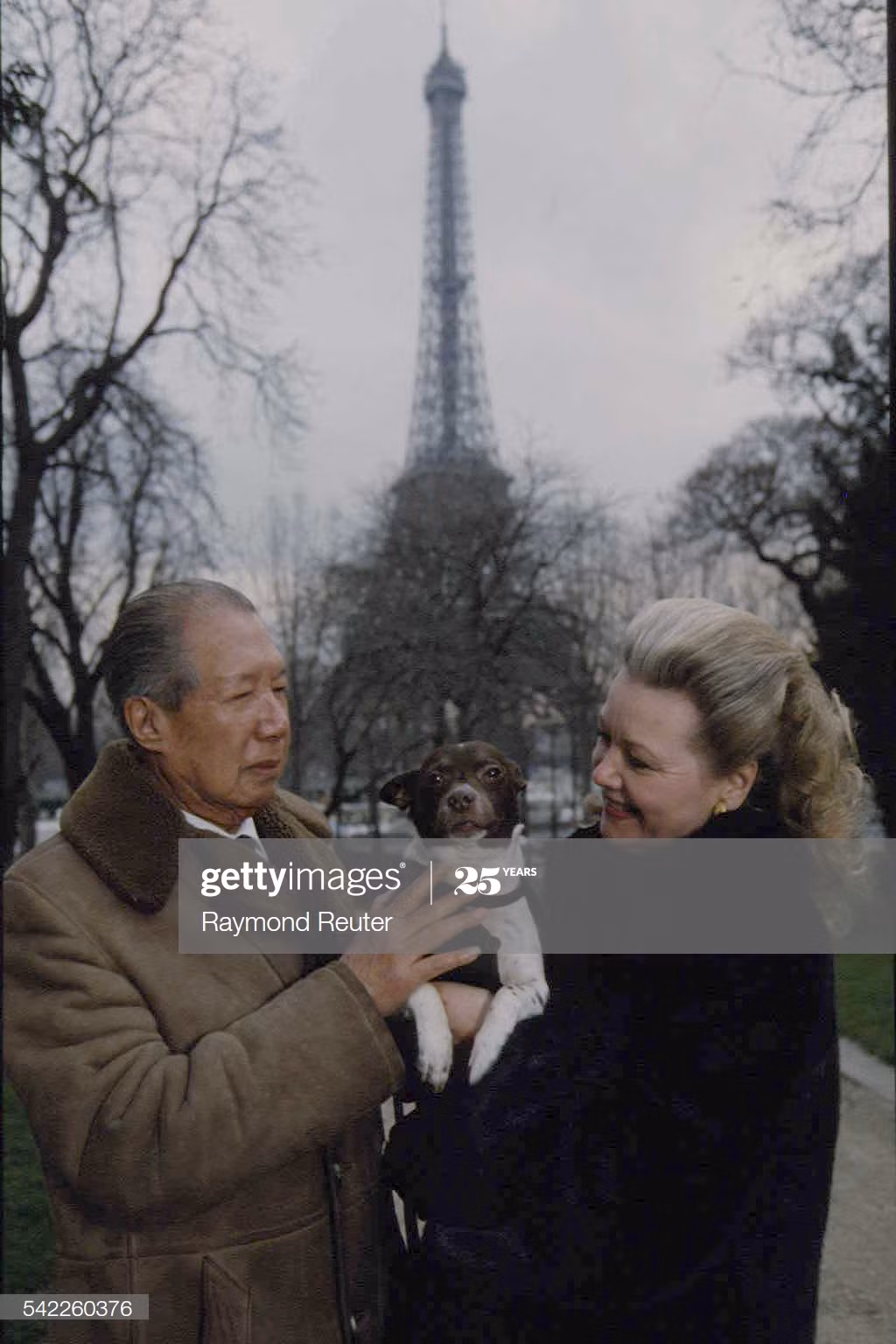 Bảo Đại và Monique Baudot đi dạo cùng chó cưng ở công viên gần tháp Eiffel, 1992. Monique Baudot đã tận tình giúp đỡ "ông vua lưu vong" và sống với ông từ năm 1971. Nhưng đến năm 1982 họ mới làm đám cưới.