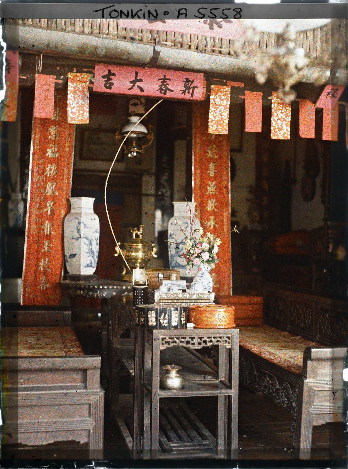 Cận cảnh chiếc bàn giữa phòng khách, bên trên có bình hoa, khay gỗ khảm xà cừ đựng đồ uống trà, tráp gỗ, bát điếu...