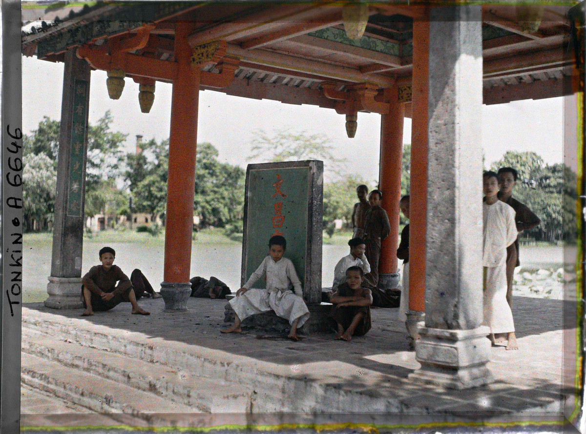 Trẻ con và khách vãng lai tránh nắng trong đình Trấn Ba.