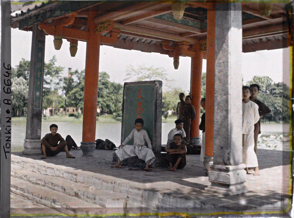 Trẻ con và khách vãng lai tránh nắng trong đình Trấn Ba.