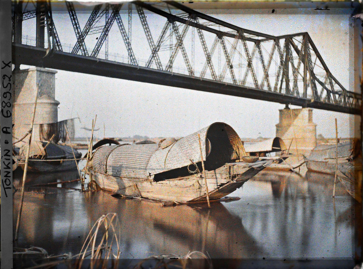 Những con thuyền tam bản dưới chân cầu buổi sáng.