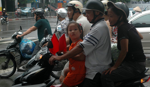 2 tay 2 lá cờ tung tăng cùng cha mẹ trên phố Tây Sơn, Đống Đa, Hà Nội.