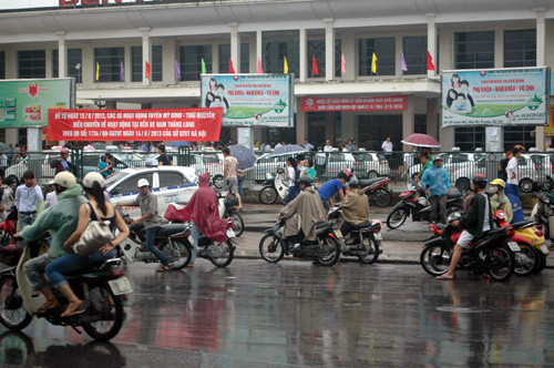 Nhiều người đứng dưới mưa chờ người thân.