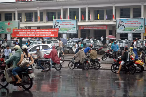 Nhiều người đứng dưới mưa chờ người thân.