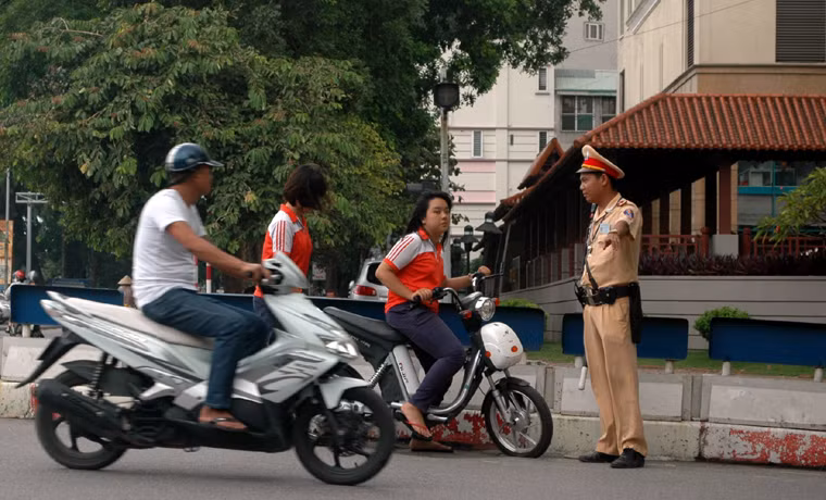 2 học sinh đi xe đạp điện trên đường Thanh Niên, quận Tây Hồ, Hà Nội, không đội MBH bị CSGT ra hiệu lệnh dừng xe xử lý.