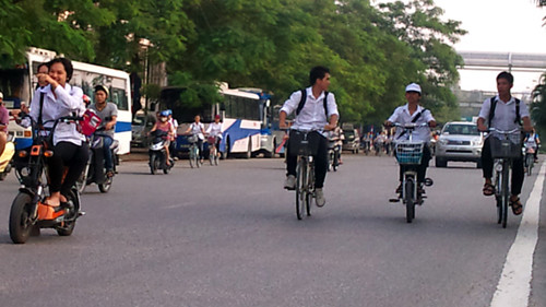 Các em học sinh đi xe đạp điện thản nhiên giăng hàng 3 giữa đường.
