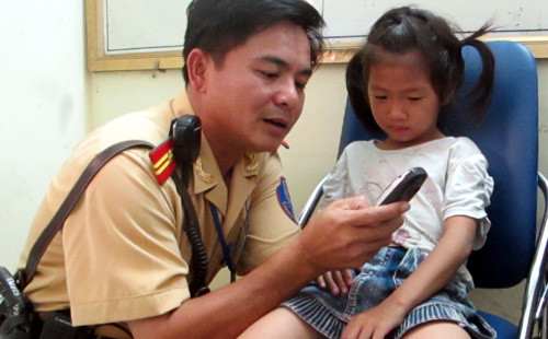 Cháu bé bị lạc gia đình đang được CSGT chăm sóc.