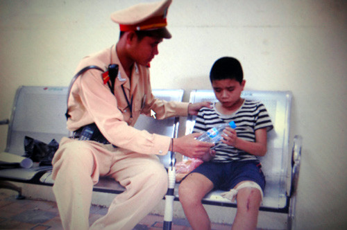 Chiến sĩ CSGT đưa thức ăn, nước uống cho cháu bé.