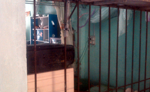 Kẻ trộm bẻ cửa song sắt tiến vào nhà lấy trộm điện thoại.