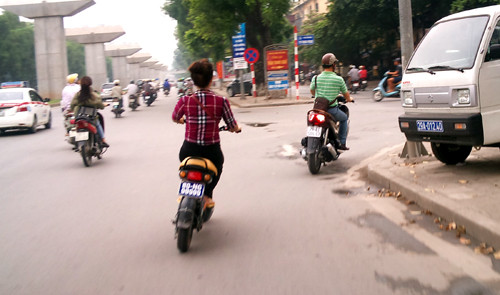 Cô gái đầu trần điều khiển xe đạp điện treo biển "khủng" chuyển làn đường không có tin hiệu xin đường.