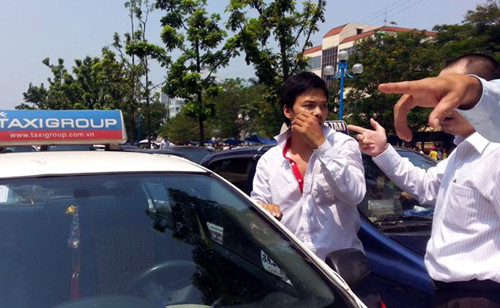 Lái xe taxi bị người đi đường cùng người dân khu vực giữ lại.