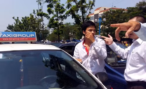 Lái xe taxi bị người đi đường cùng người dân khu vực giữ lại.