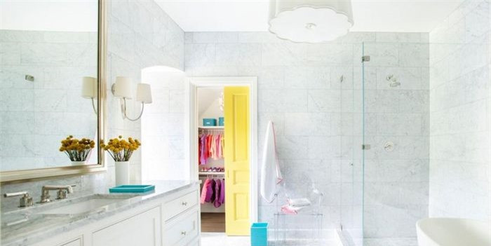 Phòng tắm dành cho trẻ em thoáng mát này sử dụng đá cẩm thạch từ sàn đến trần. Điểm nhấn là đèn chiếu sáng hình vỏ sò và cửa sổ màu vàng để thu hút thị giác. 