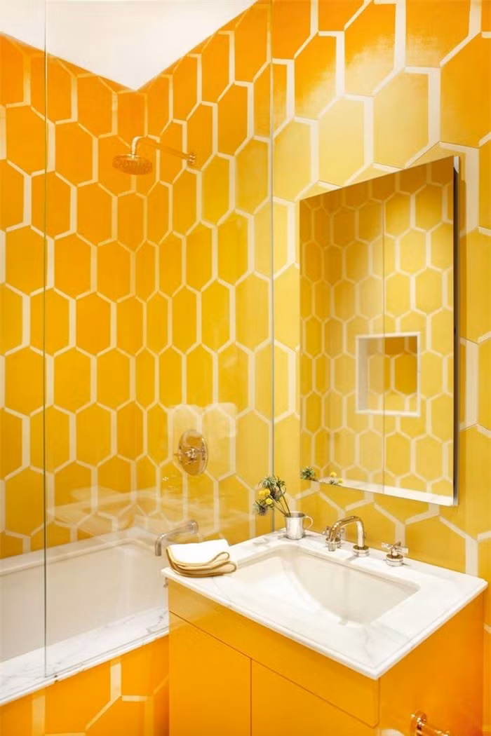Nhà thiết kế đã sử dụng gạch màu vàng đậm và bàn trang điểm bổ sung để làm nổi bật phòng tắm dành cho trẻ em này.