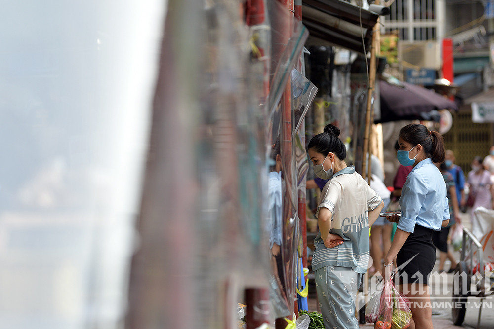 Trước tình hình diễn biến dịch Covid-19 ngày càng căng thẳng, nhiều chợ trên địa bàn Hà Nội tìm các biện pháp vừa kinh doanh vừa chống dịch. Trong ảnh là các cửa hàng khu Bách Khoa căng nilon giữa người mua và người bán.