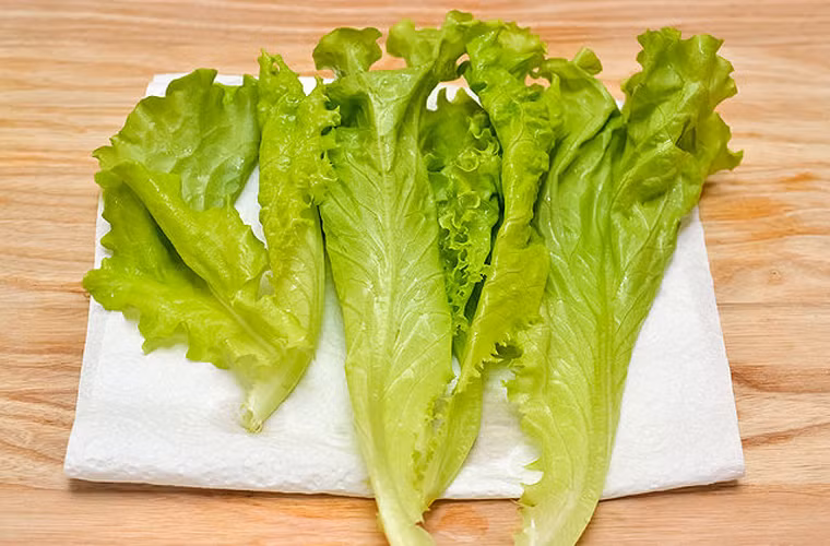 Tận dụng khăn giấy, xếp xà lách thành hàng rồi nhẹ nhàng quấn lại. Chú ý không xếp quá nhiều rau để quá trình bảo quản được lâu hơn.