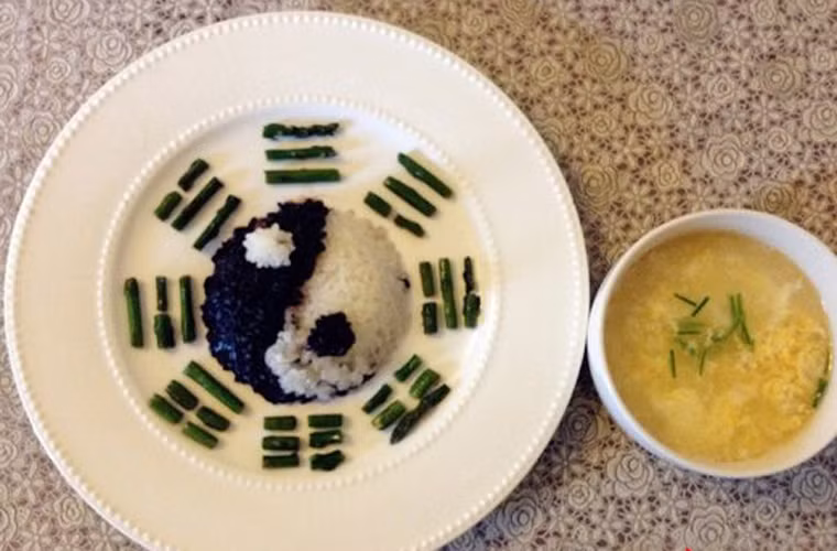 Một suất ăn sáng đơn giản với cơm, rau xanh được mô phỏng hình vòng xoáy âm dương.