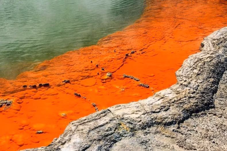Gần bờ hồ là màu cam sáng do antimon lắng đọng và kết tủa tạo thành.