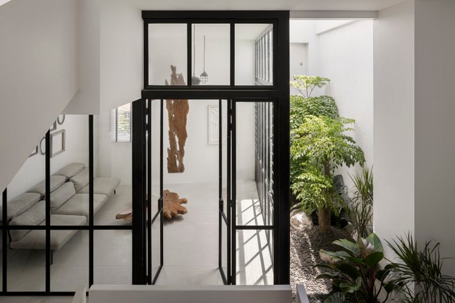 Bước vào bên trong, căn nhà tạo cảm giác rộng rãi, thông thoáng nhờ trần nhà được thiết kế cao và sử dụng gạch lớn đồng nhất. Thêm vào đó, màu trắng chủ đạo cũng góp phần "đánh lừa thị giác", mở rộng không gian. Đồng thời, những bức tường trắng cũng làm tốt vai trò phông nền, tôn lên vẻ đẹp của các chi tiết nội thất cho tổng thể căn nhà.