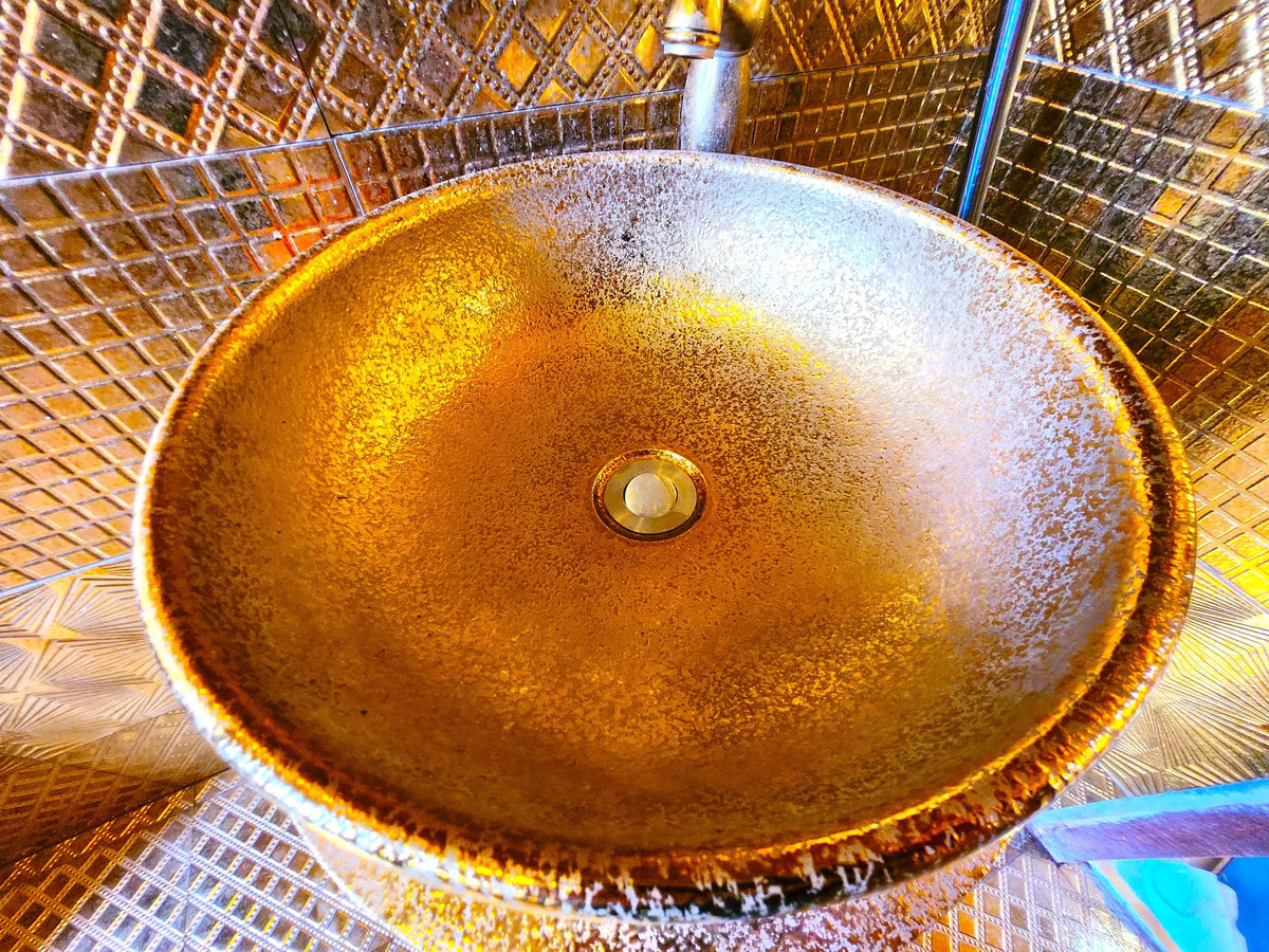 Nhà vệ sinh ngay cạnh phòng khách và phòng karaoke được bao phủ một màu vàng. Nhiều phụ kiện bên trong nhà được dát vàng 24k và vàng công nghiệp.