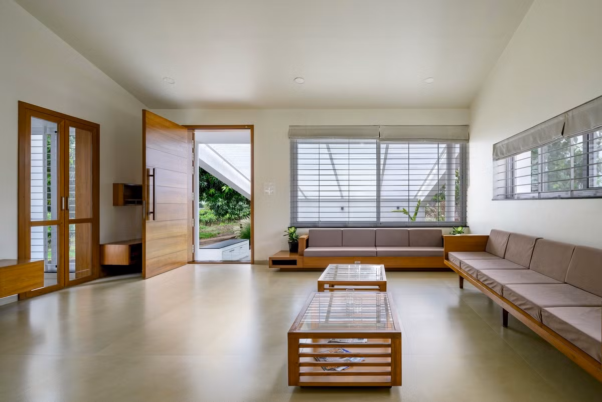 Gạch lát sàn màu be nhạt với lớp hoàn thiện mờ được sử dụng trên toàn bộ không gian, cùng với tông màu gỗ tếch Miến Điện đồng nhất được sử dụng cho đồ nội thất, để tạo nên sự hấp dẫn về mặt xúc giác cũng như thị giác cho ngôi nhà.