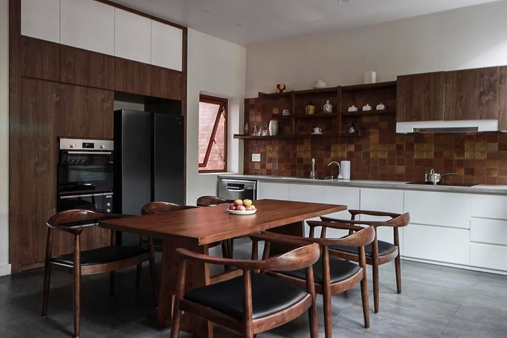 Phần mái “vén” có chức năng đón gió vào nhà được chống đỡ bằng một cây cột ốp gỗ - hình ảnh cột nhà quen thuộc trong kiến trúc truyền thống Việt Nam.