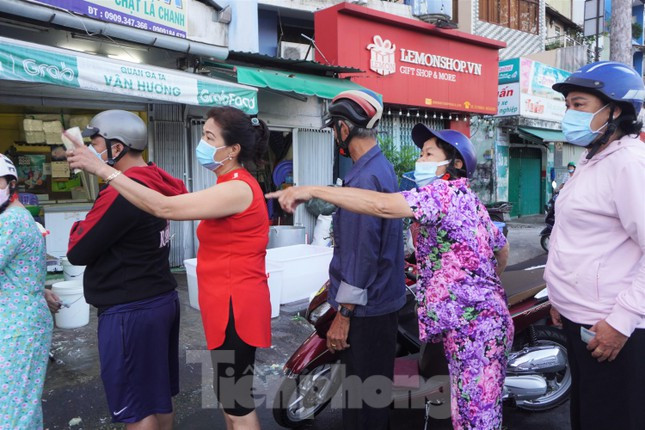 Bà Minh Tâm (áo đỏ) cho biết đã xếp hàng chờ gần 1 tiếng đồng hồ để mua gà. "Năm nào tôi cũng đến cửa hàng gà này mua về cúng khai trương, ở đây bán gà rất ngon, chờ lâu một chút cũng không sao", bà Tâm chia sẻ.