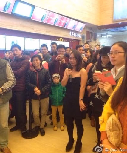 Hình ảnh một cô gái trẻ mặc váy ngắn đen đã cầm nhẫn cầu hôn bạn trai mình ngay trong rạp chiếu phim ở Hạ Môn, Phúc Kiến, Trung Quốc và chàng trai trông chẳng vui vẻ gì khi cô gái hành động như vậy.