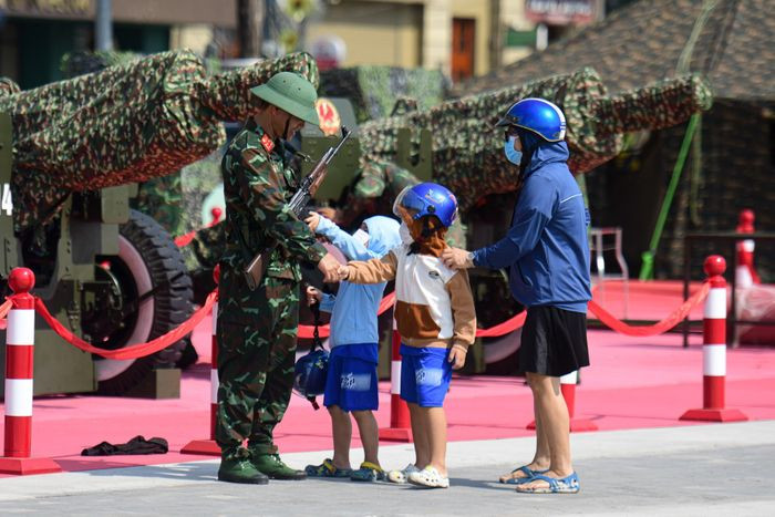 Nhiều người dân TP.HCM tranh thủ chụp ảnh, chào hỏi những chiến sĩ đang thực hiện nhiệm vụ lắp đặt pháo ở bến Bạch Đằng.