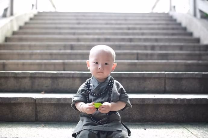 Tiểu hòa thượng đã vắt tràng hạt làm hai vòng để thuận tiện chạy nhảy chơi đùa ngoài sân chùa.