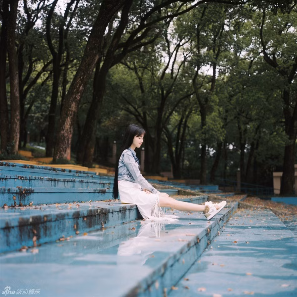 Hot girl đẹp dịu dàng tại hàng ghế của rạp chiếu phim ngoài trời trong khuôn viên trường.