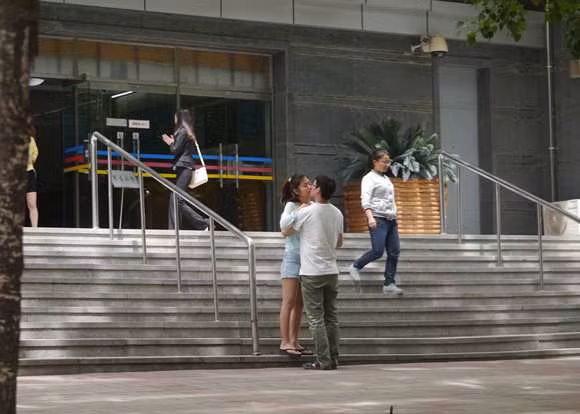 Hôn nhau đắm đuối trước cửa một tòa nhà lớn đông người qua lại mà không hề ngại ngần.