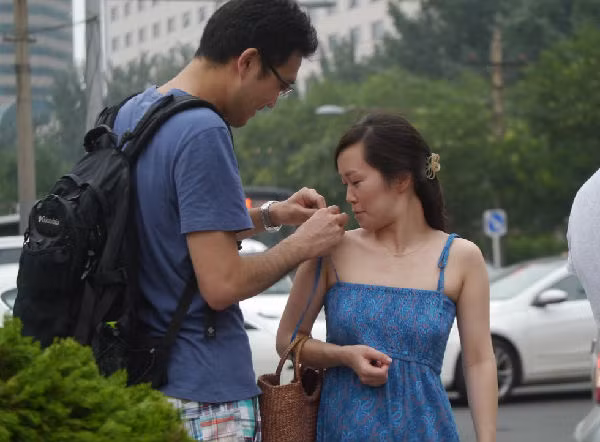 Buộc lại dây váy đã tuột cho bạn gái rất tự nhiên.