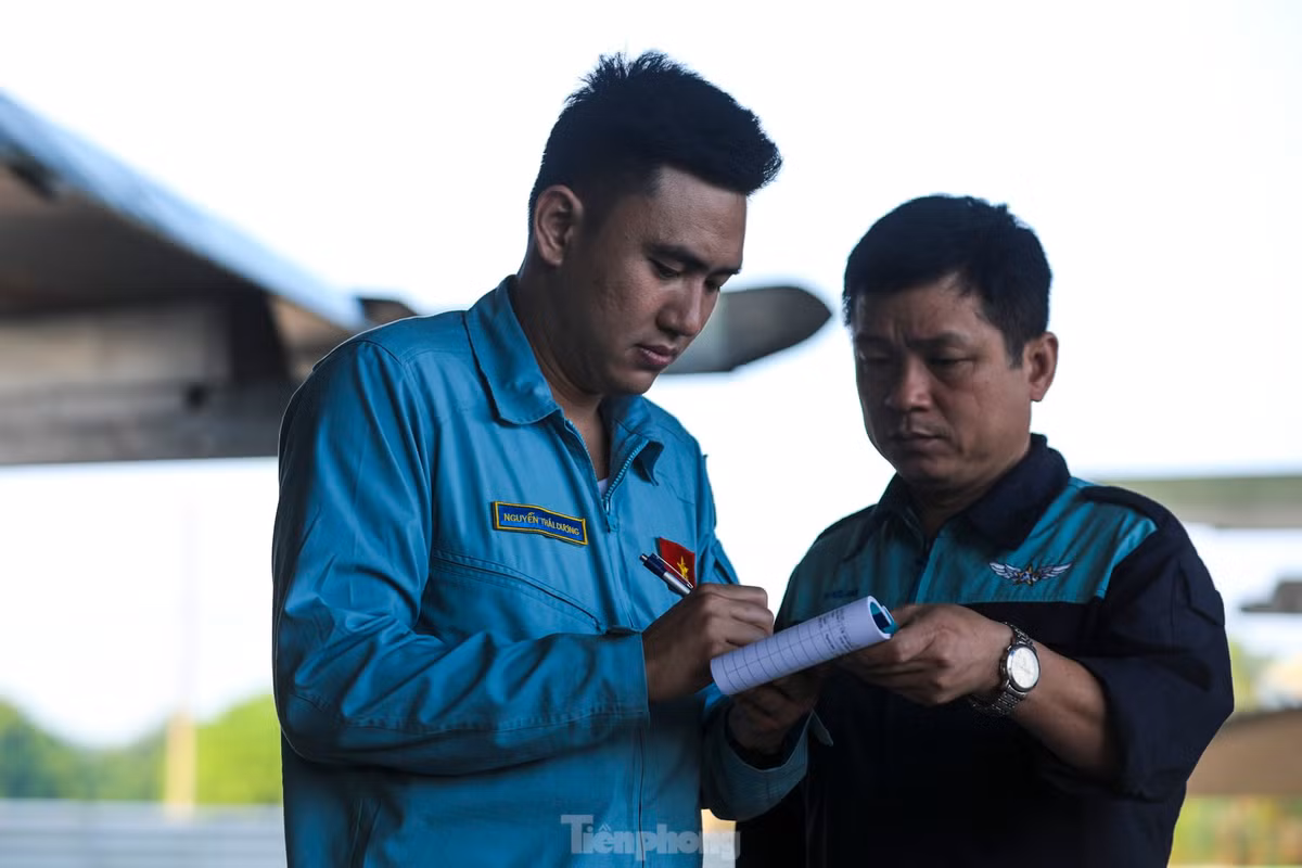 Phi công Nguyễn Thái Dương ký biên bản xác nhận cùng nhân viên kỹ thuật sau khi kiểm tra từng góc cạnh của động cơ, thân máy bay.