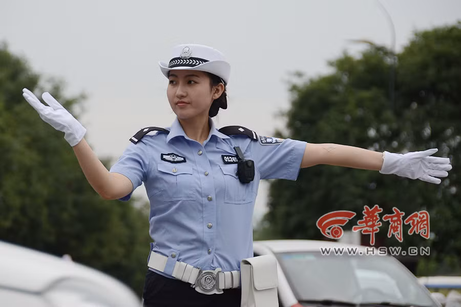 Đặc biệt vào giờ cao điểm, luôn tay luôn mắt và thấm mệt nhưng nữ cảnh sát vẫn luôn giữ nụ cười tươi tắn trên khuôn mặt.